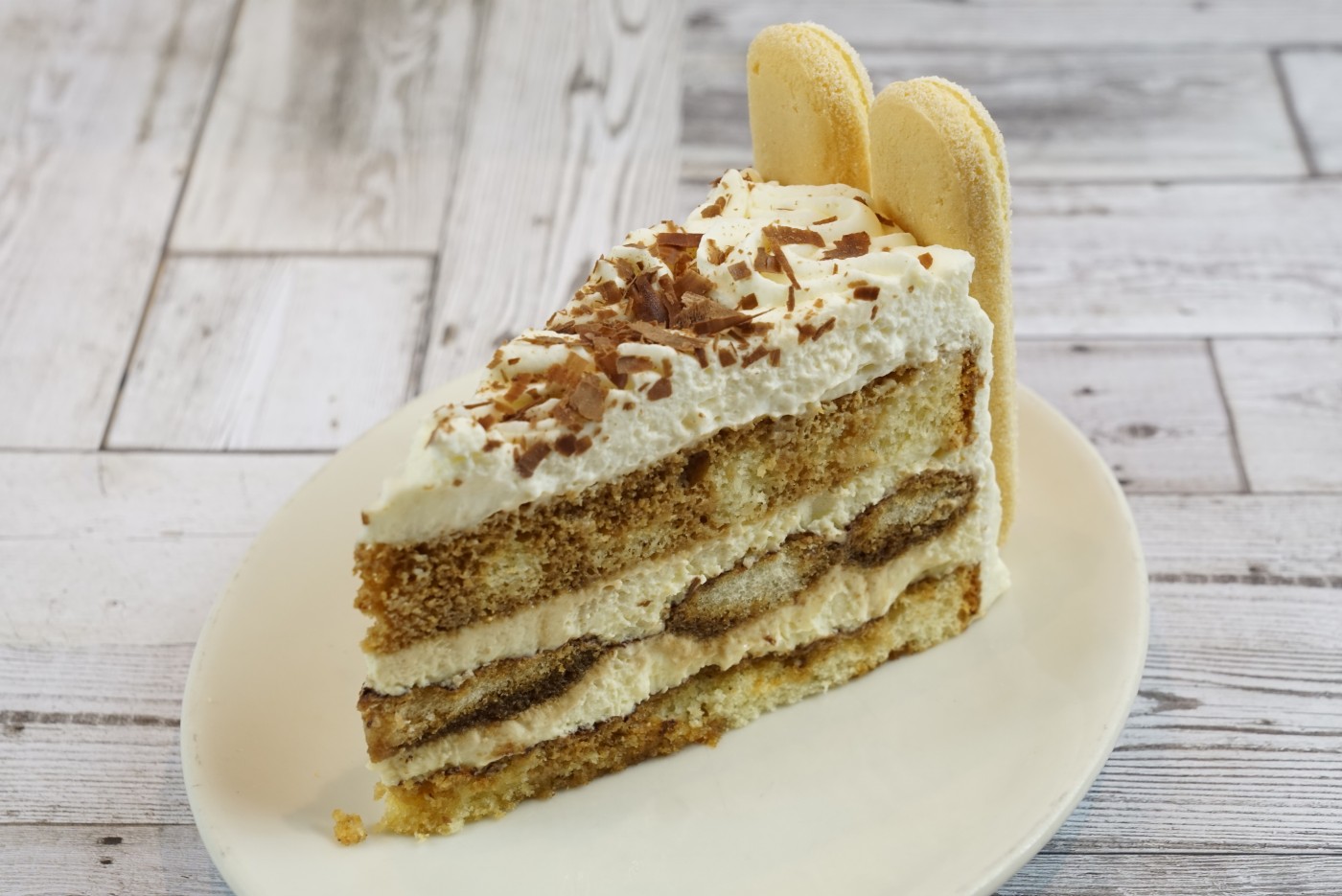 tiramisu slice savor the classic flavor of a traditional tiramisu slice at Mia's Bakery.