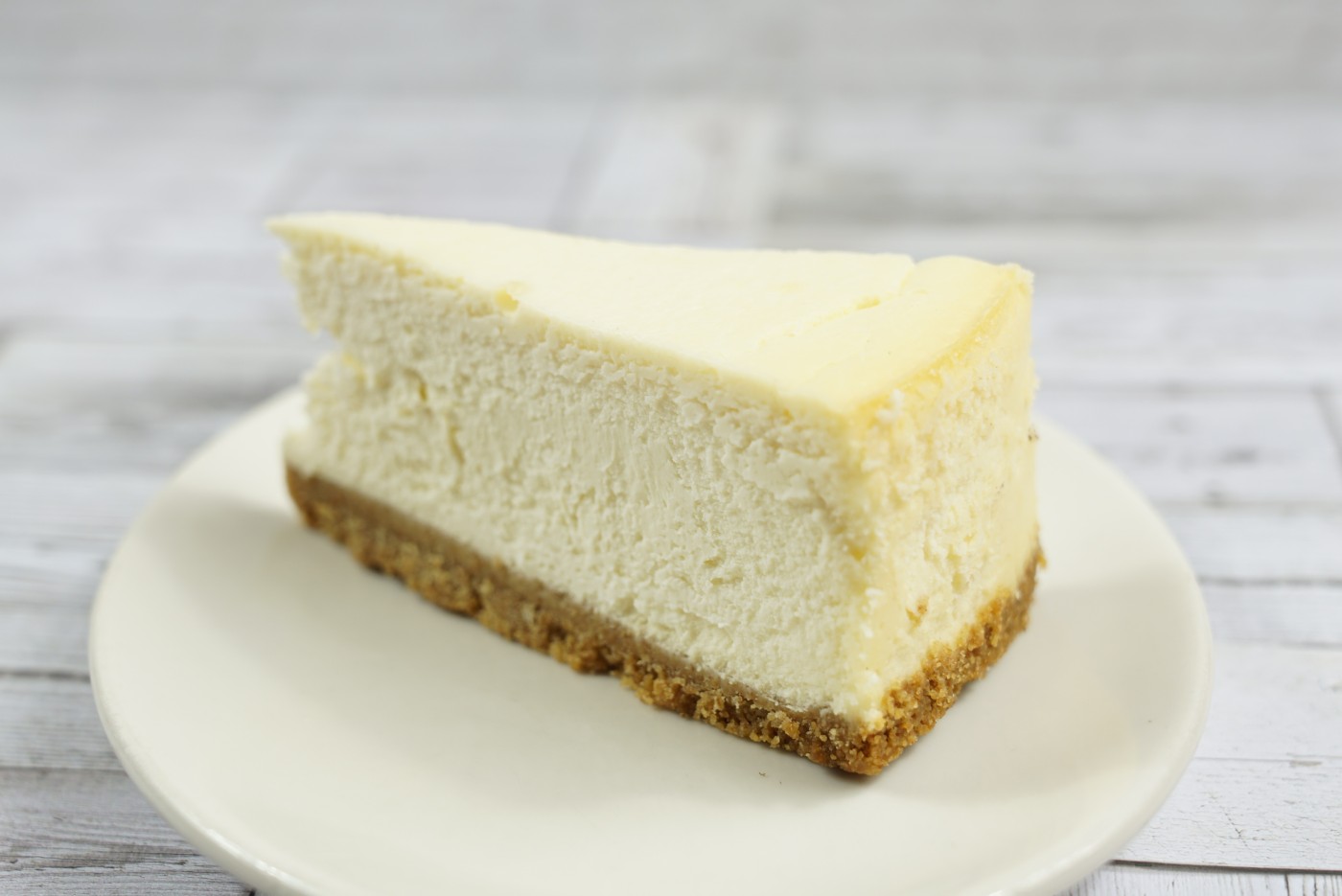 New York cheesecake slice savor the classic flavor of a traditional New York cheesecake slice at Mia's Bakery.