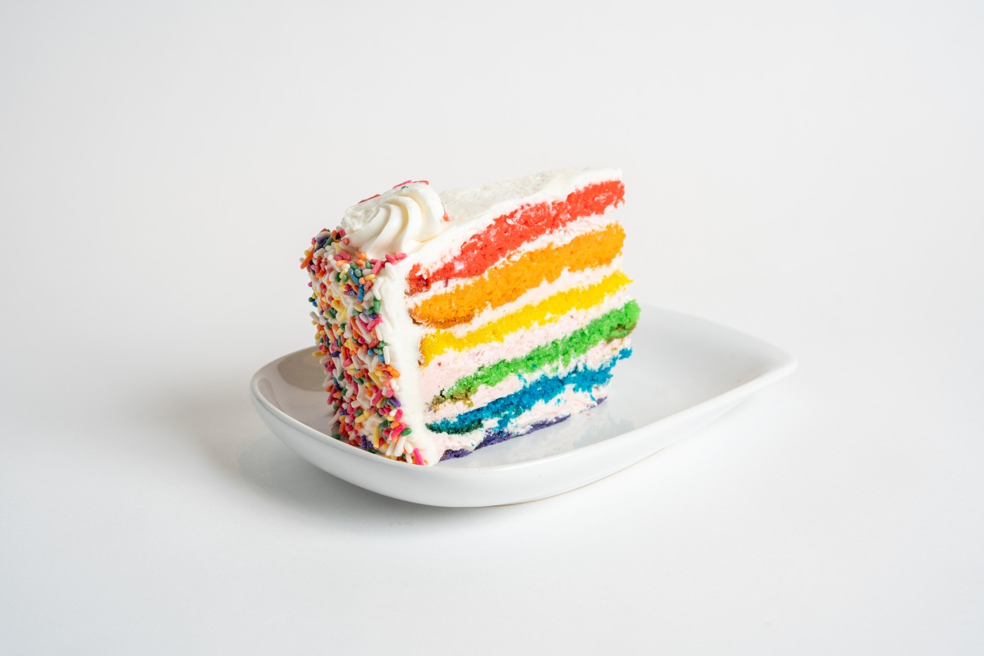 rainbow cake slice savor the classic flavor of a traditional rainbow cake slice at Mia's Bakery.