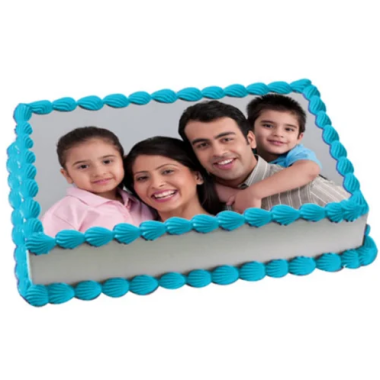 Custom edible image cake displaying a happy family portrait of parents with two children, featuring blue scalloped piped borders around the rectangular cake. This personalized photo cake from Mia's Bakery showcases the family's smiling faces printed on an edible sugar sheet topper on white frosting. Perfect for family celebrations, birthdays, and special occasions.