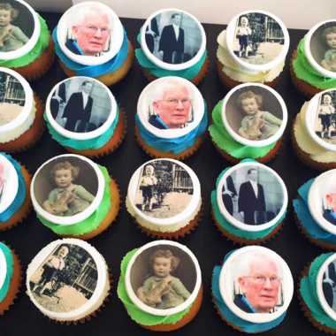 Collection of edible image cupcakes featuring historical photographs and portraits printed on round fondant toppers with colored borders. These custom photo cupcakes from Mia's Bakery display vintage portraits and historical scenes in green and blue circular frames on vanilla cupcake bases. Perfect for heritage celebrations, museum events, and history-themed parties, showcasing professional edible image printing on individual cupcakes.