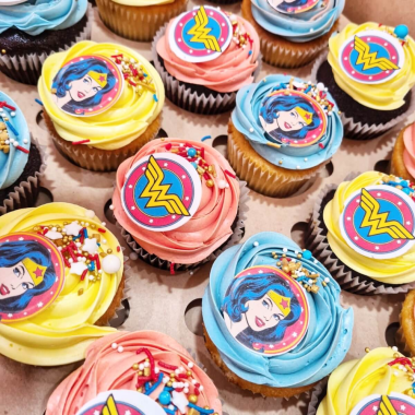 Colorful assortment of edible image cupcakes featuring Mr. Tumble character portraits printed on round toppers. These custom photo cupcakes from Mia's Bakery showcase vibrant yellow, pink, and blue swirled buttercream frosting with character images from the children's TV show. Mix of vanilla and chocolate cupcake bases decorated with edible printed Mr. Tumble faces, perfect for children's birthday parties and character-themed celebrations.