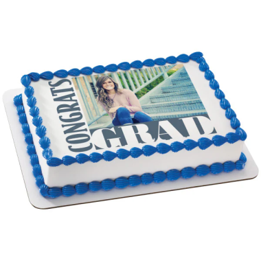 Rectangular edible image cake featuring a graduate in cap and gown sitting on concrete steps, with "CONGRATS GRADUATE" text on the edible photo print. This custom photo cake from Mia's Bakery displays the graduation portrait on white frosting, surrounded by blue ball piped borders. Perfect for graduation celebrations and academic achievement parties, showcasing personal photos on edible sugar sheet toppers.