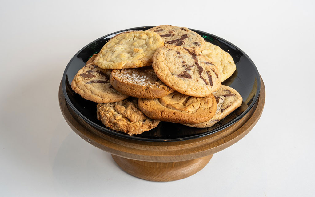 Assorted spring cookie ideas including chocolate chip and sugar cookies arranged on a wooden cake stand