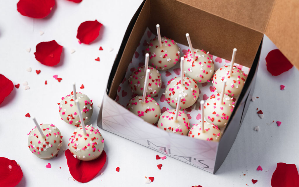 Mother's Day dessert ideas with white chocolate cake pops decorated with pink heart sprinkles in gift box